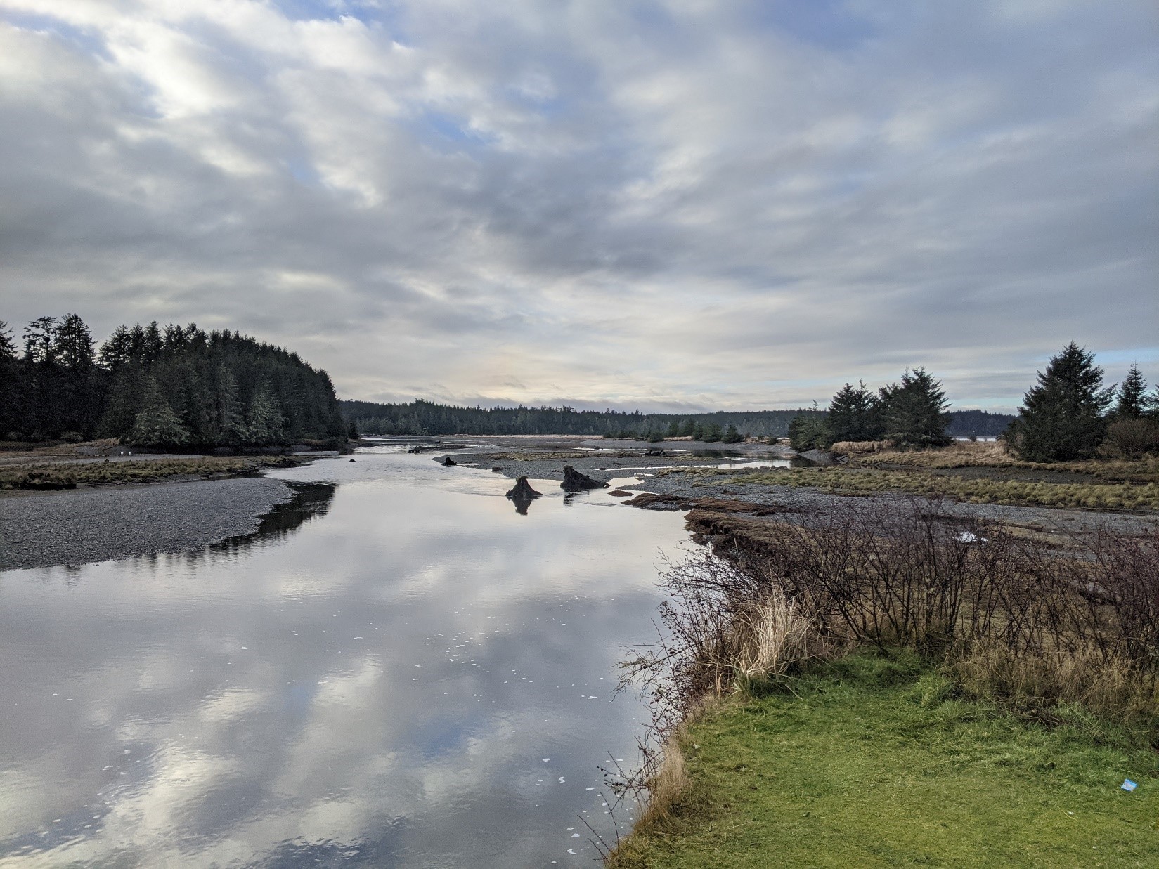 The Cluxewe River follows a natural berm parallel to shore for several hundred meters parallel to the shoreline before opening up into Queen Charlotte Strait.